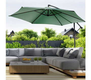De 909 Outdoor Hangende Parasol in de kleur groen werpt schaduw over een loungeset.