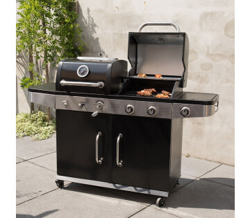 De SUMM Magnus Hybride Barbecue Gas & Houtskool staat in de tuin.