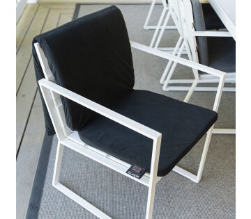 De Warmigo Dual Heatzone Draadloze Stoelverwarming ligt over een tuinstoel. 