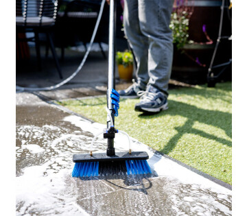Wasborstel met steel in gebruik op terras schoonmaken