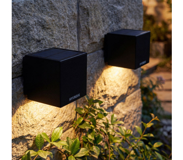 Kubus wandlampen op zonne-energie gemonteerd op stenen muur met verlichting