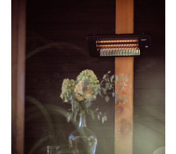 Sunred Lugo terrasverwarmer gemonteerd aan wand in overkapping met sfeerverlichting