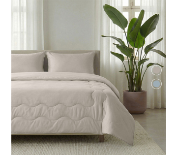 Beige dekbed op bed in moderne slaapkamer met grote plant naast het bed