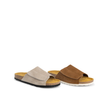 Twee paar suède slippers voor dames in beige en bruin naast elkaar