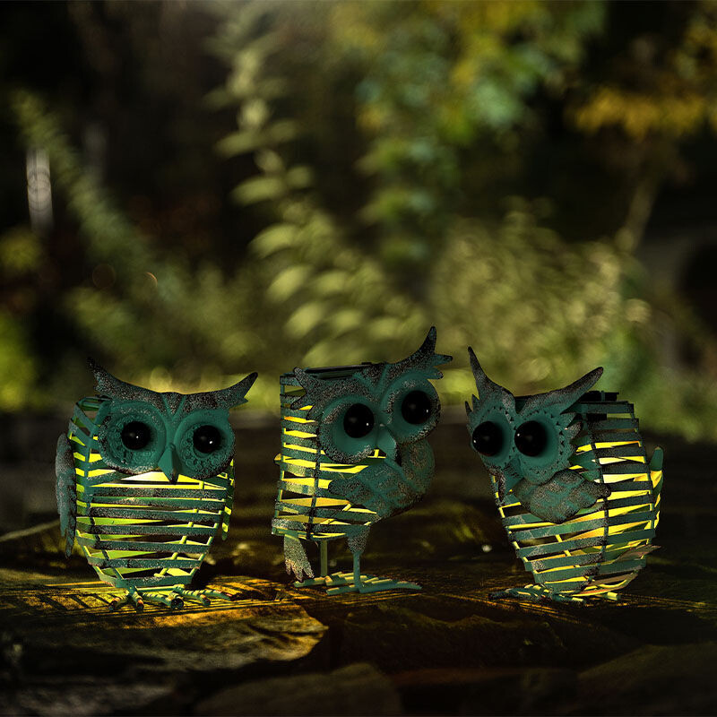 De Set van 3 Hyundai Lighting Solar Tuinlampjes Vintage Owl staat buiten in het donker. 