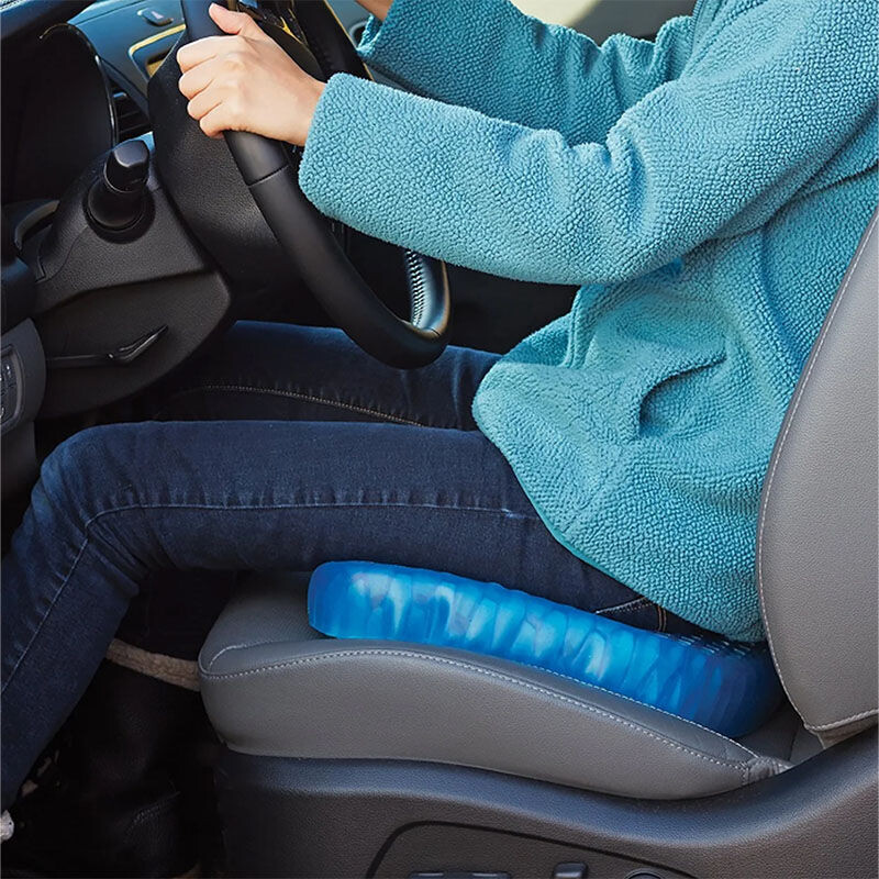 Persoon zit comfortabel op het Nexxt Gelkussen Drukverlagend Supercomfort tijdens een autorit voor extra ondersteuning van rug en billen.