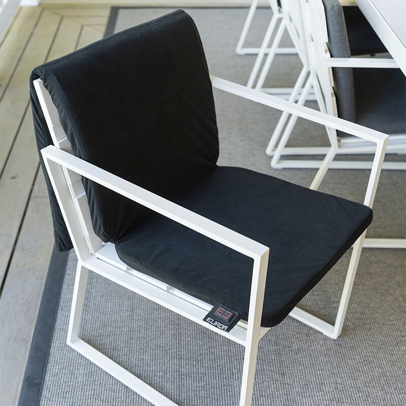 De Warmigo Dual Heatzone Draadloze Stoelverwarming ligt over een tuinstoel. 