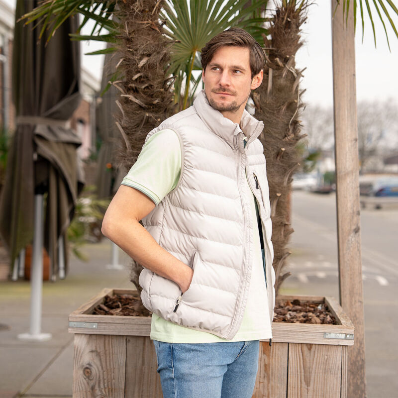 Een man draagt de Mario Russo bodywarmer in de kleur beige.