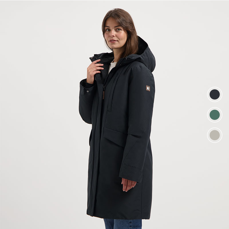 Zijaanzicht van vrouw met donkerblauwe Travelin’ Linea dames parka met capuchon. Zijaanzicht van vrouw met donkerblauwe Travelin’ Linea dames parka met capuchon.