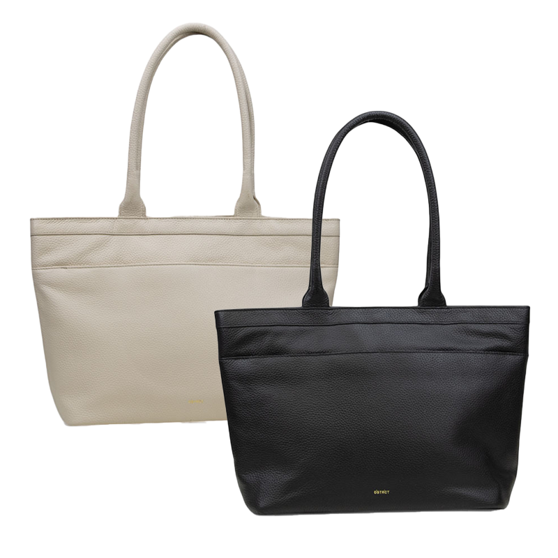 Twee DSTRCT leren shoppers, één in beige en één in zwart, getoond naast elkaar tegen een witte achtergrond.