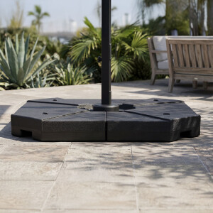 Parasoltegels in gebruik onder hangende parasol op terras met natuurlijke tuinomgeving.
