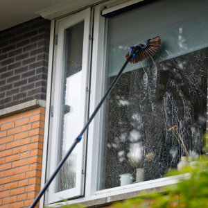 NEXXT Telescopische Waterbezem 6,5 meter in gebruik bij het reinigen van een hoog raam zonder ladder.